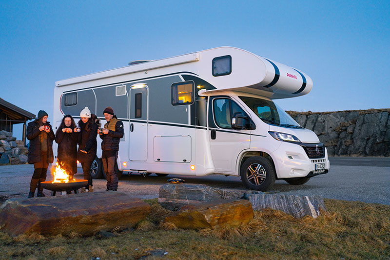 Dethleffs XL Family Alkoven mit Campern vor Grillschale beim Picknick.