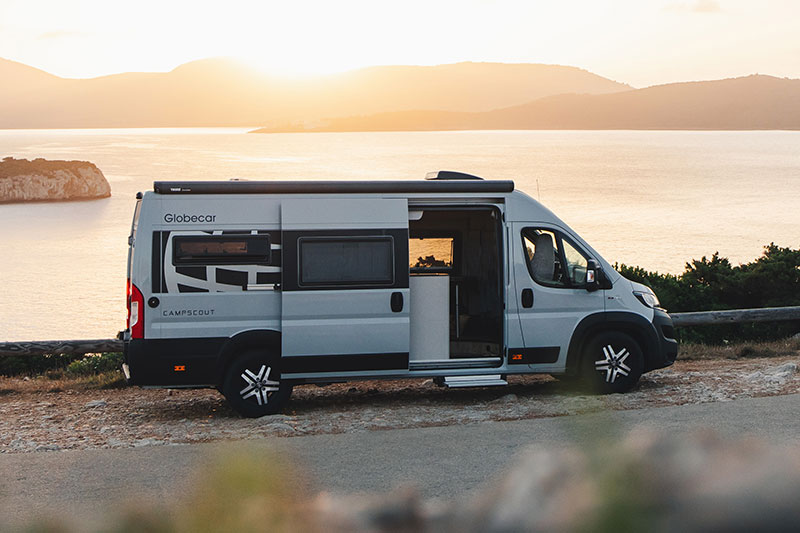 Globecar Campscout Kastenwagen vor Küstenlandschaft.